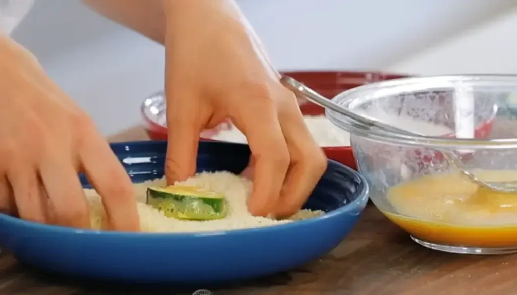 Coat zucchini slices with breadcrumbs