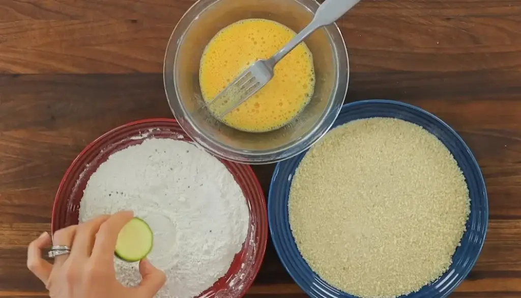 Coat zucchini slices with flour