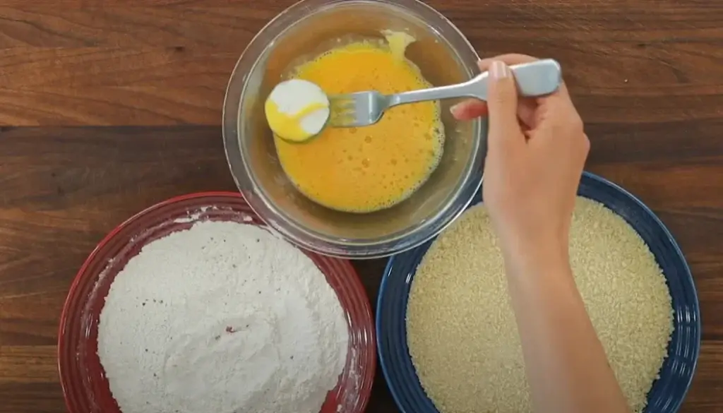 Dip zucchini slices into egg mixture